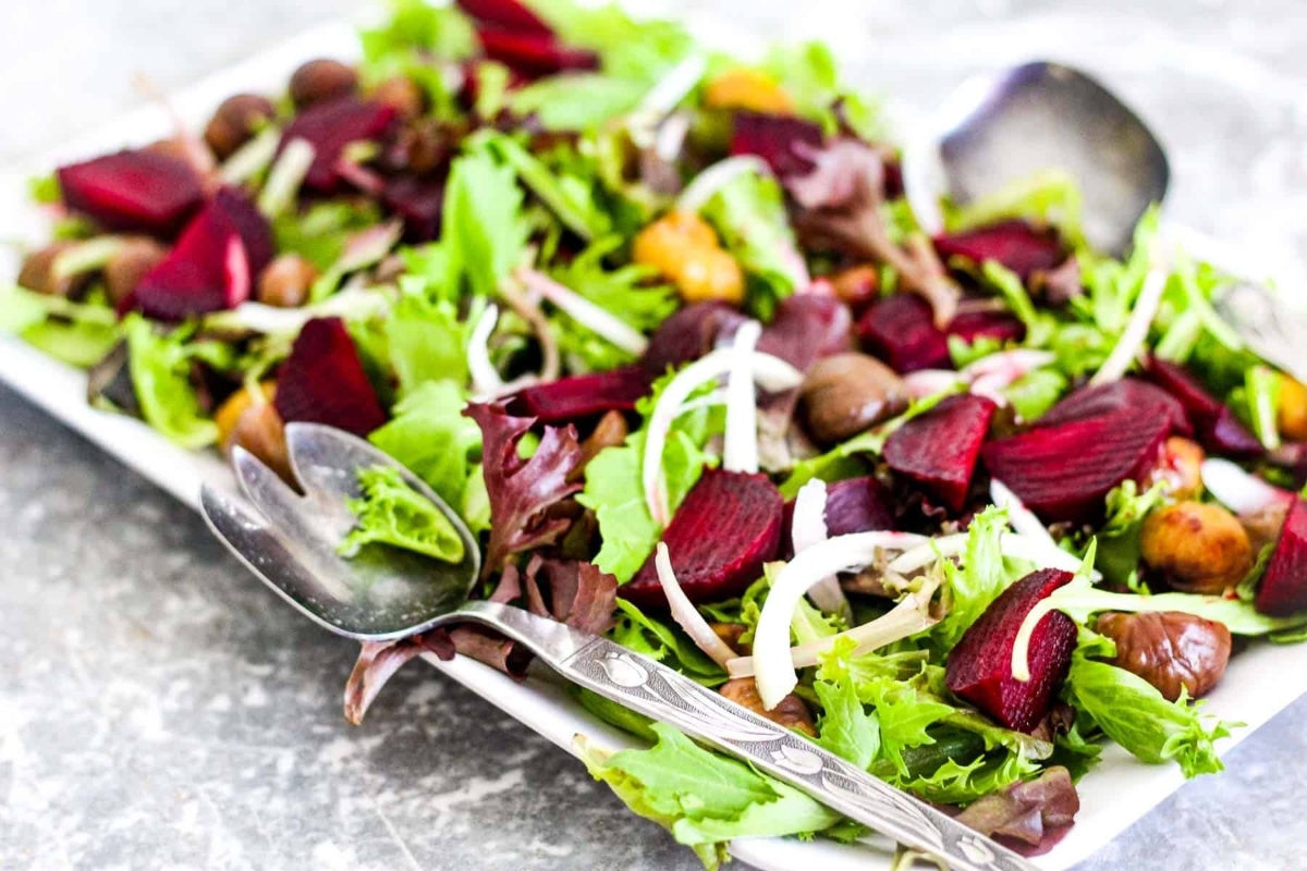 Recipe: Beet salad on a white plate with spoons.