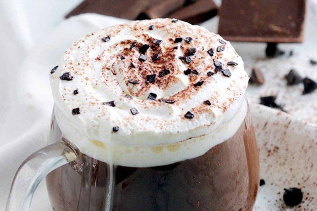         A cup of cocoa with whipped cream and chocolate chips.