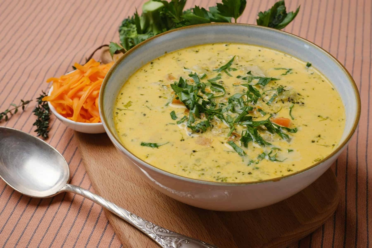 A bowl of soup with carrots and parsley, perfect for those looking for new recipes.