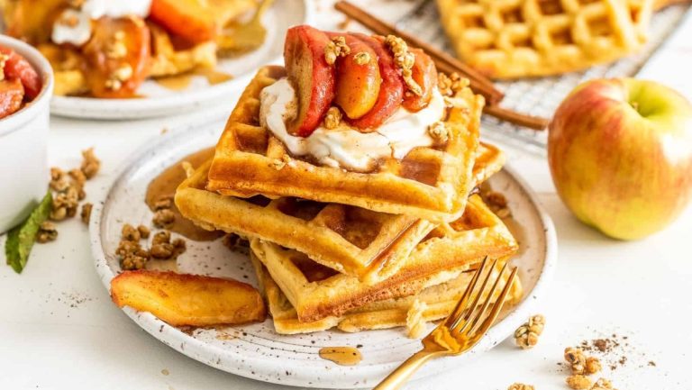 A delightful waffle recipe garnished with fresh apples and fluffy whipped cream.