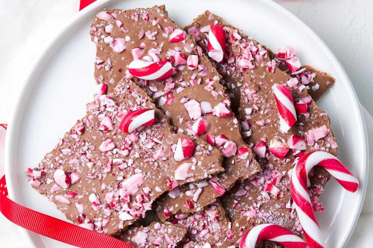 Peppermint bark on a plate with candy canes, perfect for holiday recipes and candy cane lovers.