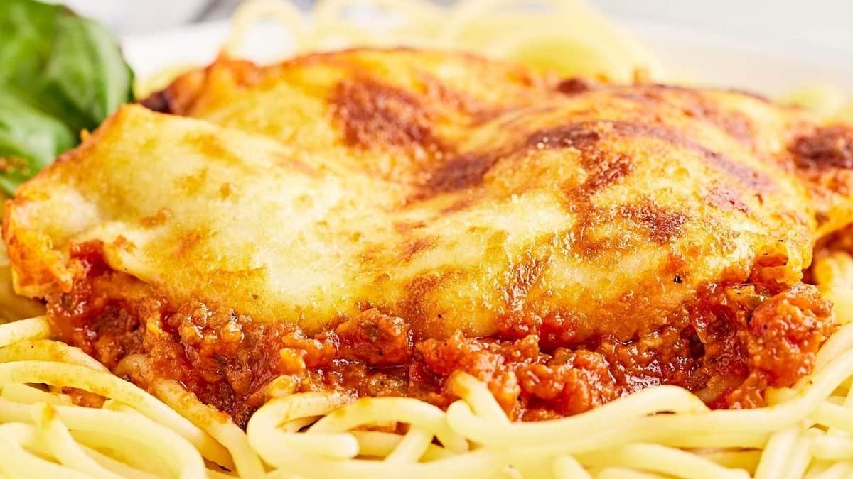 A plate of spaghetti and meatballs on a white plate.