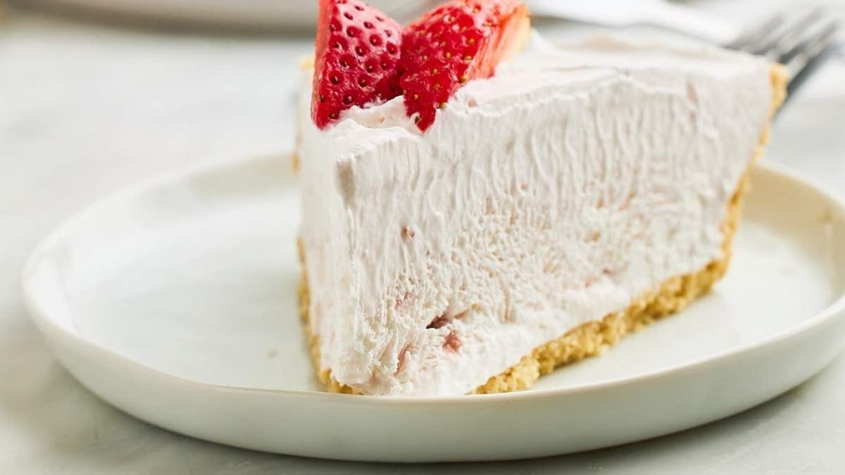A delectable slice of strawberry pie on a white plate, perfect for SHARED indulgence or a solo treat.