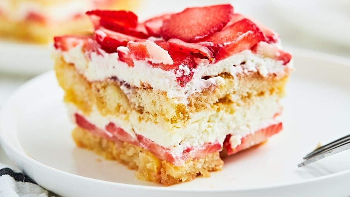 A No Bake strawberry cheesecake slice on a white plate.