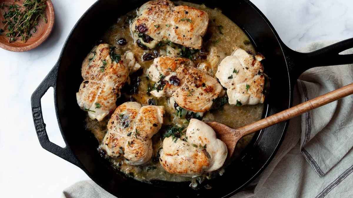 Cranberry and brie chicken in a pan.