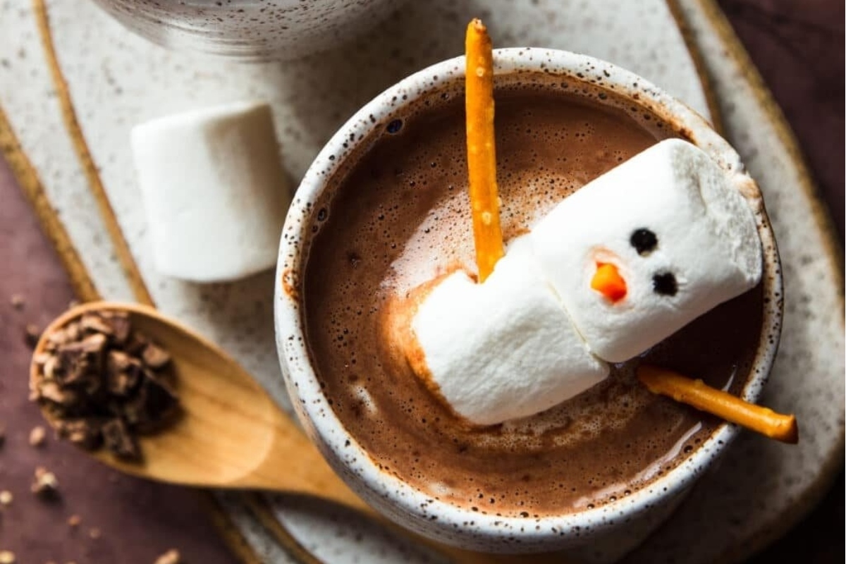 A cup of cocoa with marshmallows and a snowman.