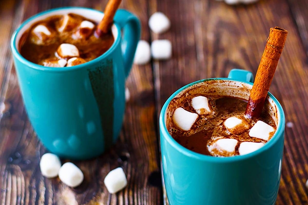 Two mugs of cocoa with marshmallows on top.