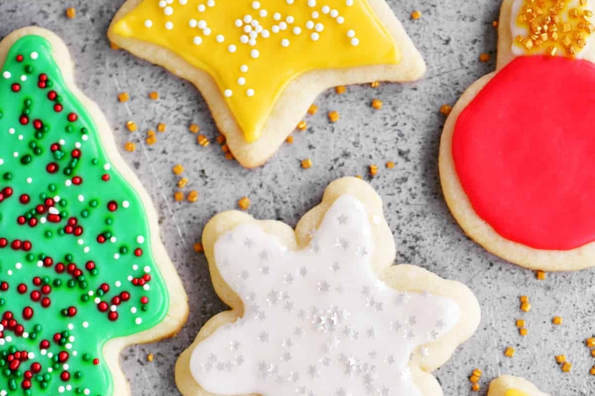 A group of Christmas sugar cookies on a gray surface.