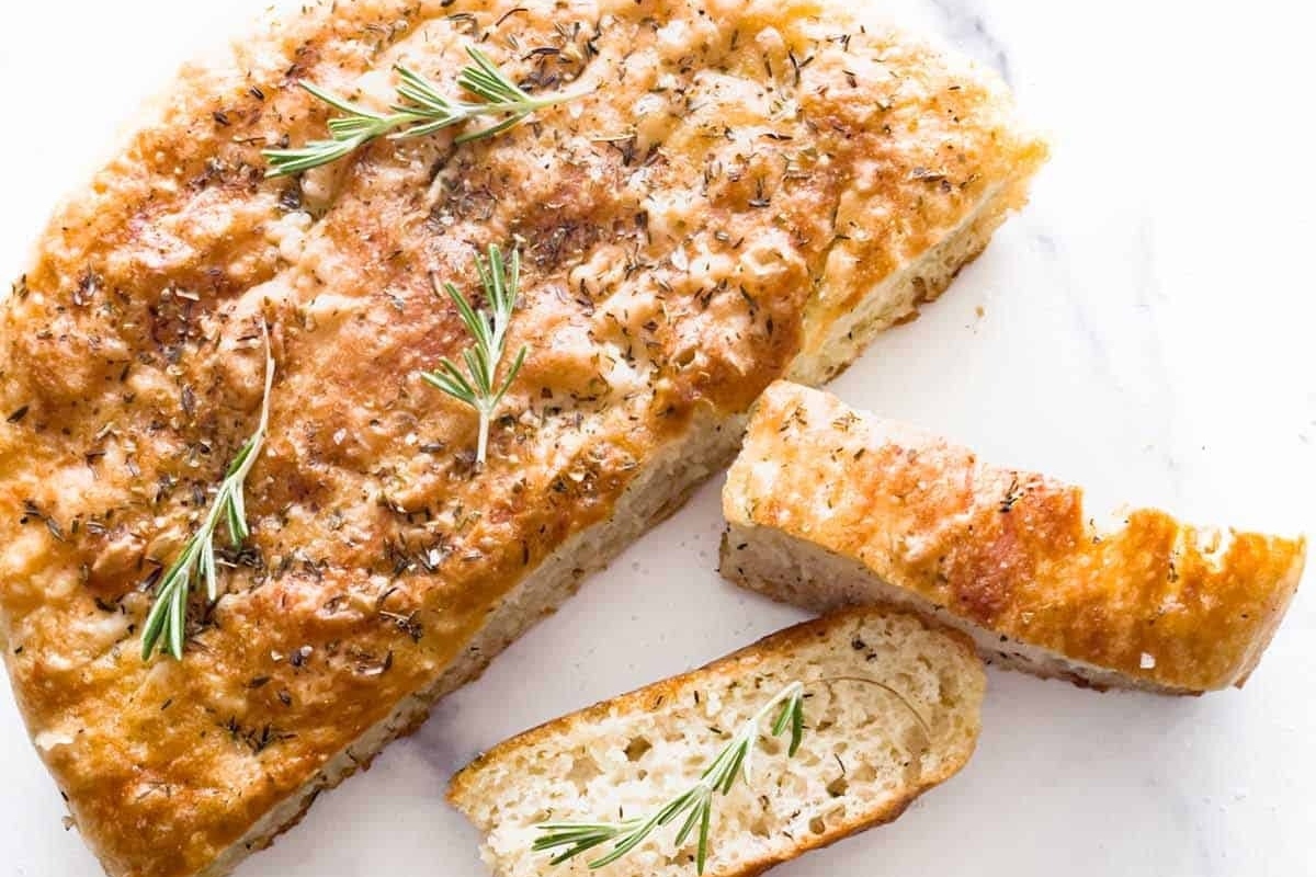 A Focaccia recipe featuring rosemary sprigs on a slice of bread.