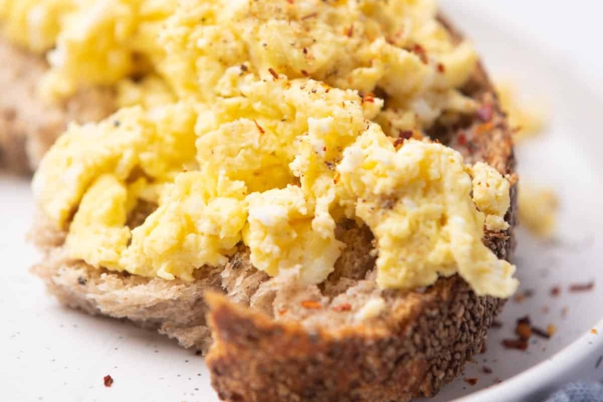 Easy breakfast recipe - Scrambled eggs on toast on a plate.