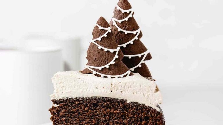 A slice of chocolate cake with a festive christmas tree on top, perfect for celebrating the holidays.