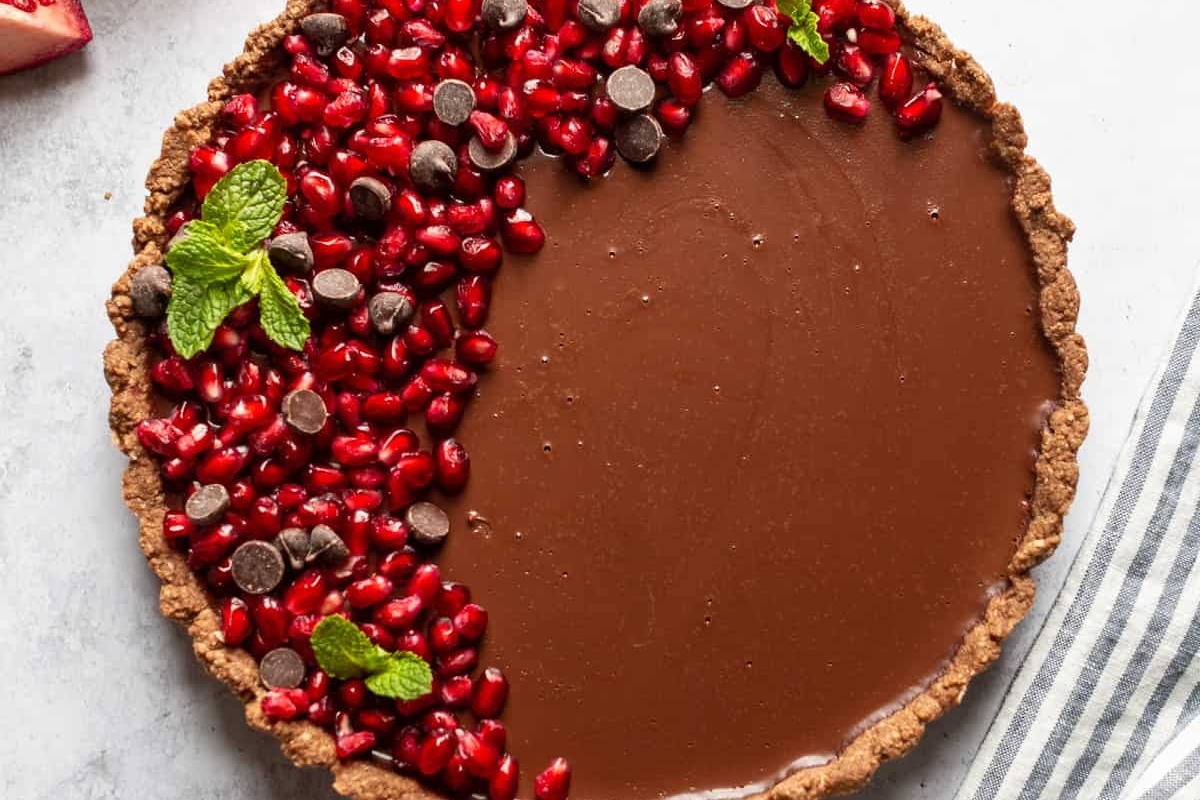 A delicious chocolate tart recipe with pomegranate and mint leaves.