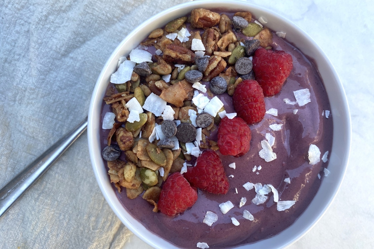 A healthy bowl filled with raspberries, granola and chia seeds; a perfect high protein breakfast option.