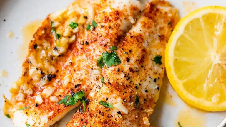 Fish fillets on a plate with lemon wedges. This recipe showcases the tantalizing flavors of fish, complemented by the zesty freshness of lemon.
