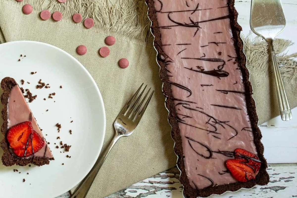 A slice of chocolate tart with strawberries on a plate, perfect for those searching for delicious tart recipes.