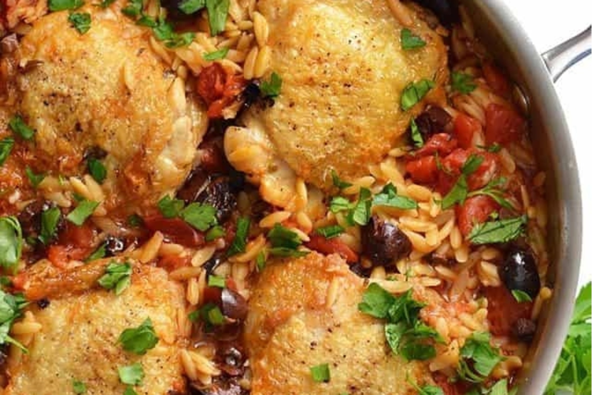 Chicken thighs and rice cooked in a skillet.