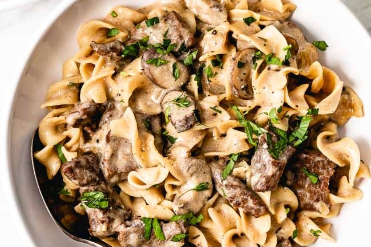 A bowl of Swedish beef stroganoff with mushrooms and parsley.