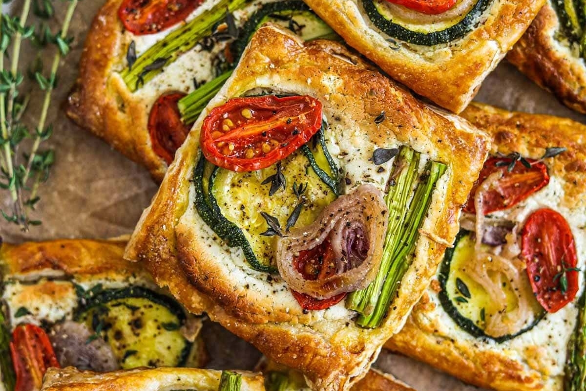 A mouthwatering plate of vegetable tarts adorned with fragrant thyme and delicate sprigs.