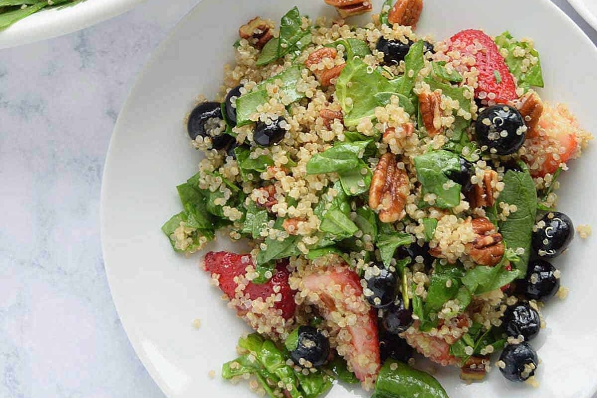 A delicious quinoa salad recipe with spinach and berries.