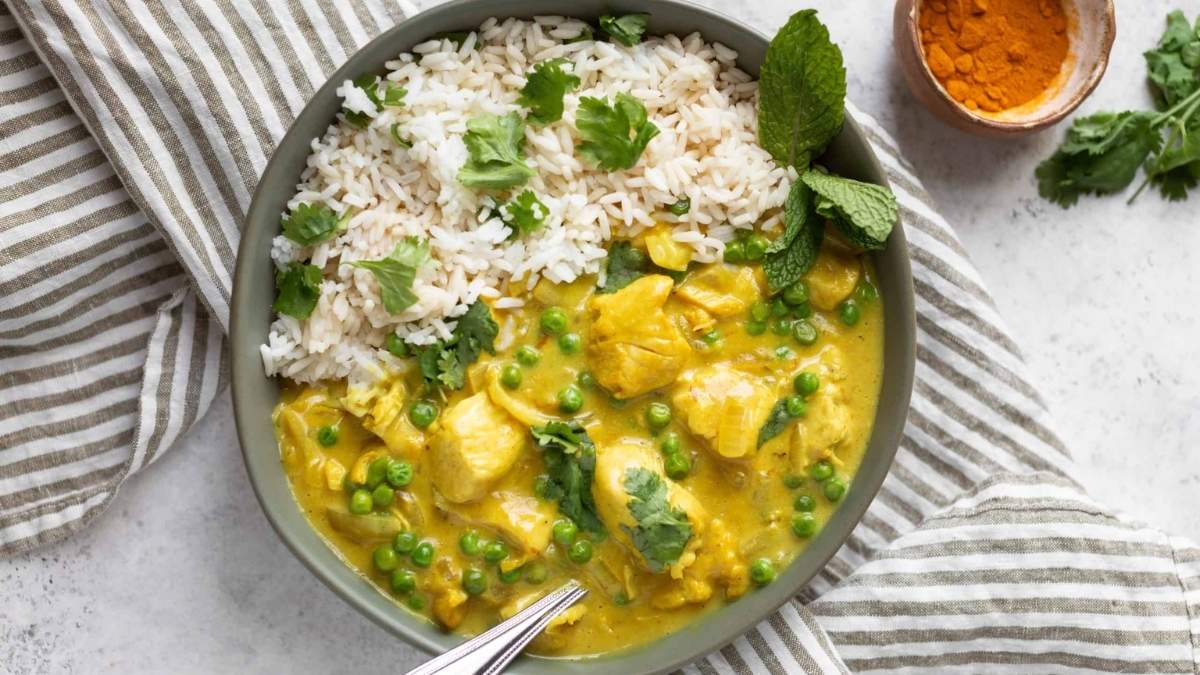 A bowl of chicken curry with rice and peas, perfect for those looking for a comforting and flavorful meal. This dish is sure to satisfy any craving for comfort food recipes.