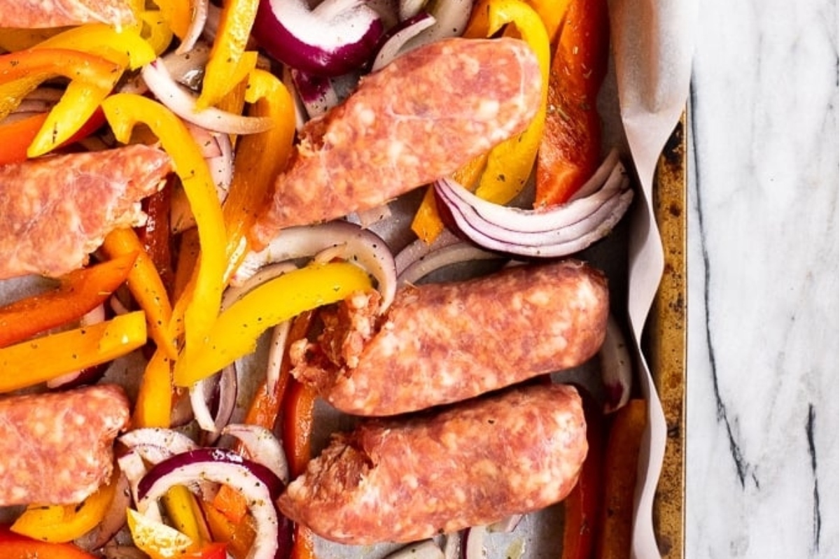 Winter dinner featuring sausage and peppers on a baking sheet.