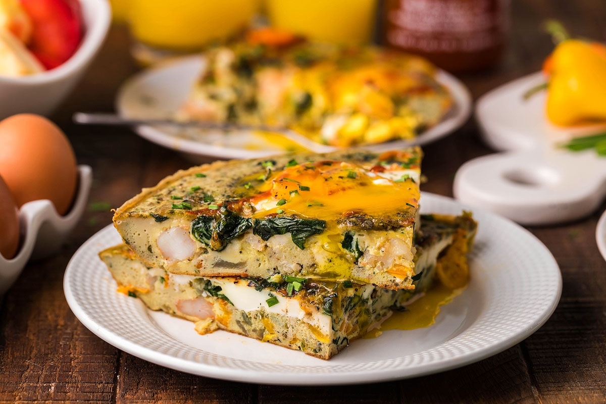 This recipe features a delightful slice of quiche loaded with fresh spinach and eggs plated elegantly for an irresistible meal.