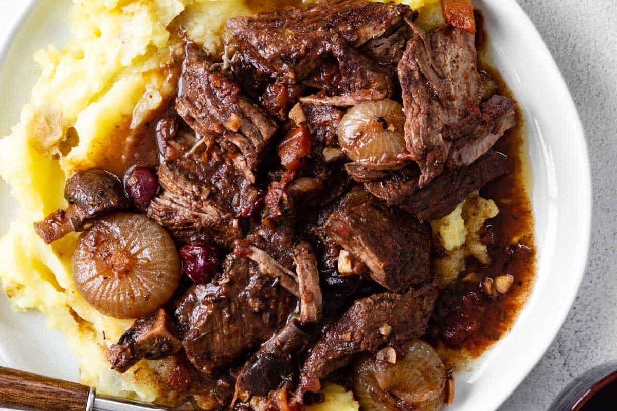 A plate with beef, mashed potatoes and cranberry sauce.