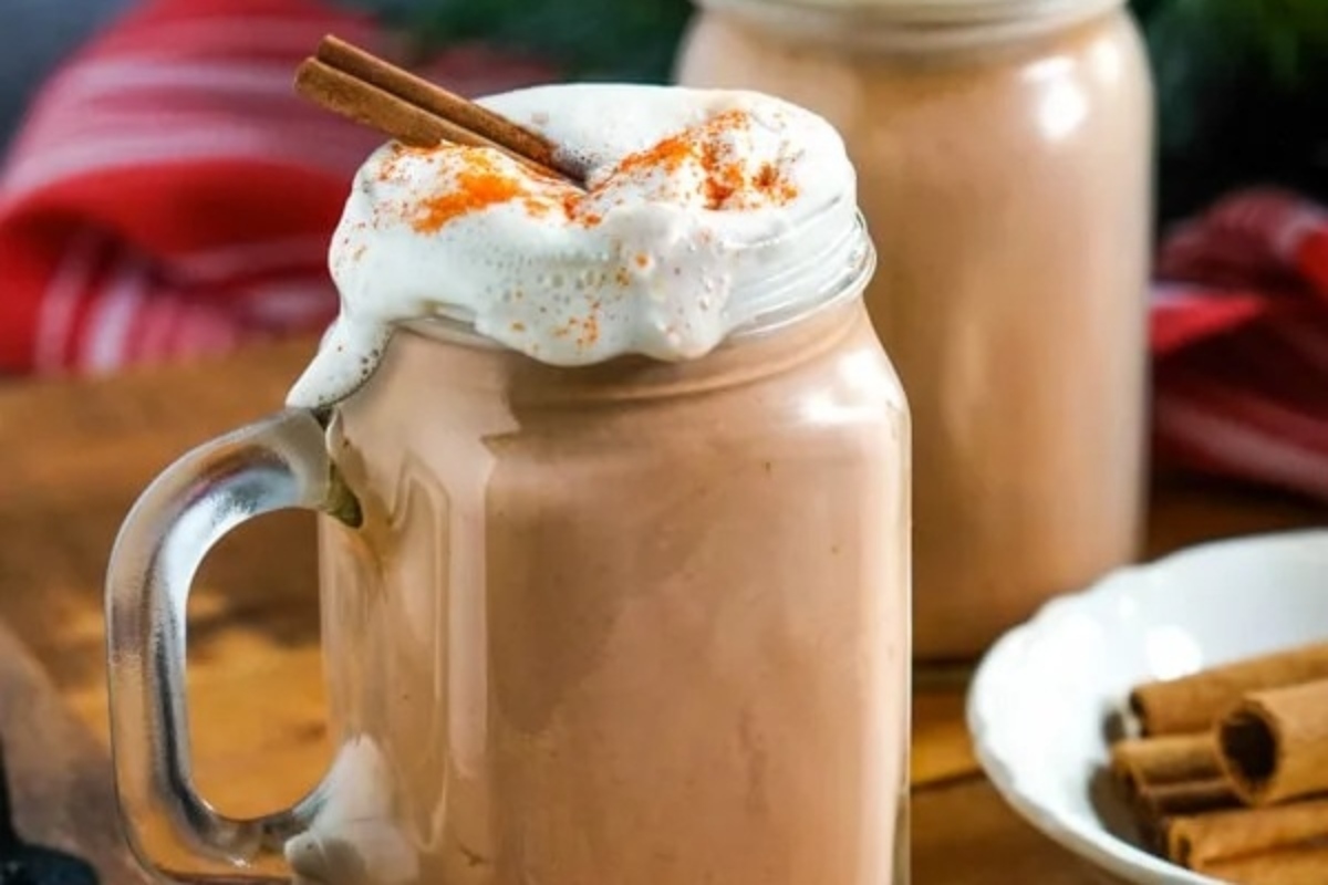 Two cocoa cups with cinnamon and whipped cream.