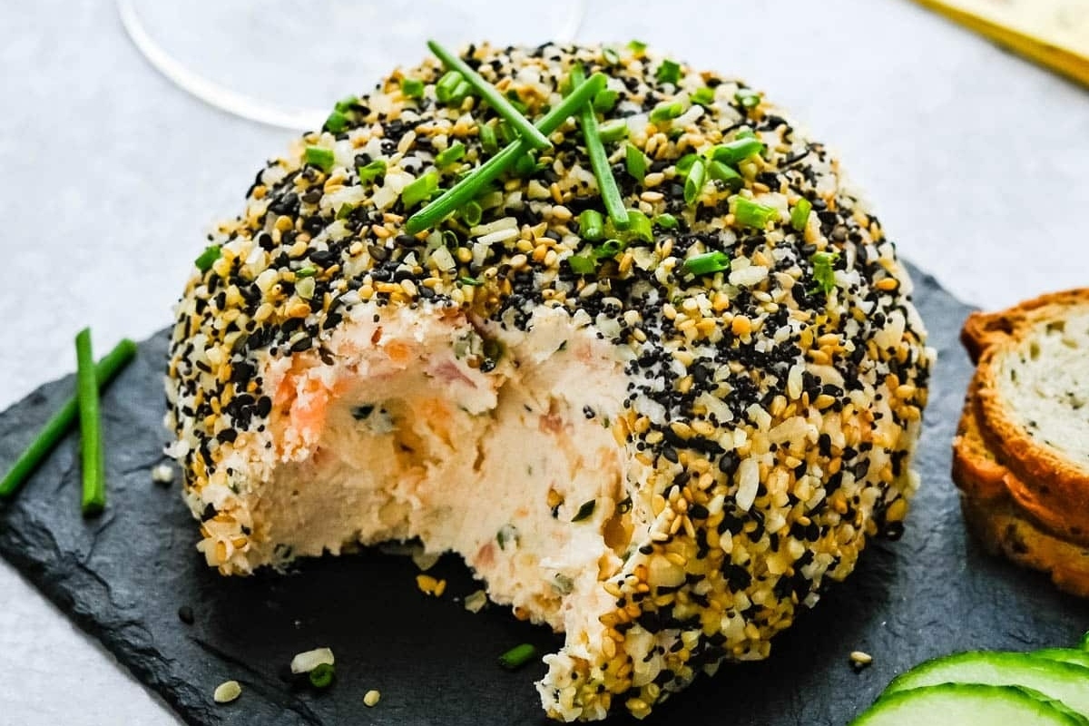 Festive salmon cheese ball with sesame seeds and cucumbers.