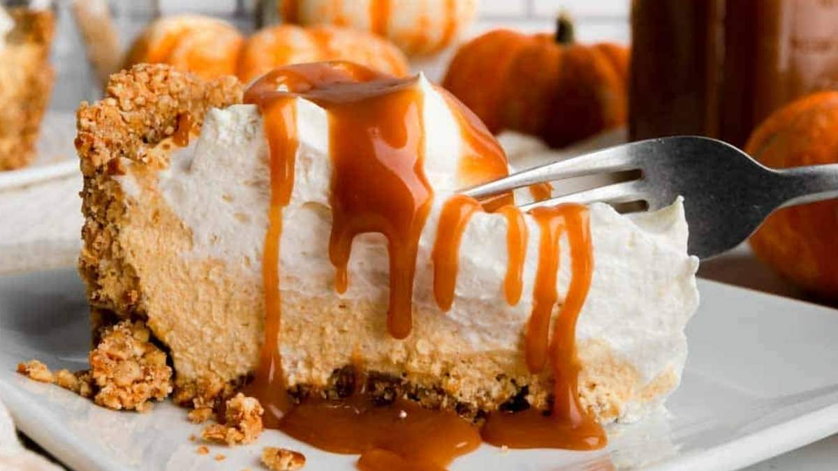A slice of pumpkin pie with caramel sauce on a plate is featured in this delightful round-up of no bake desserts.