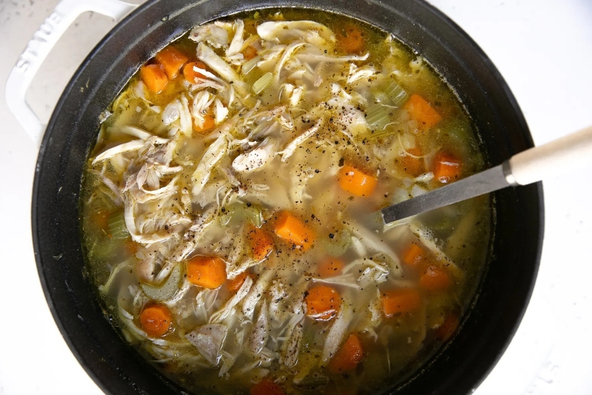 A bowl of chicken noodle soup with carrots that is perfect for inexpensive family dinners.