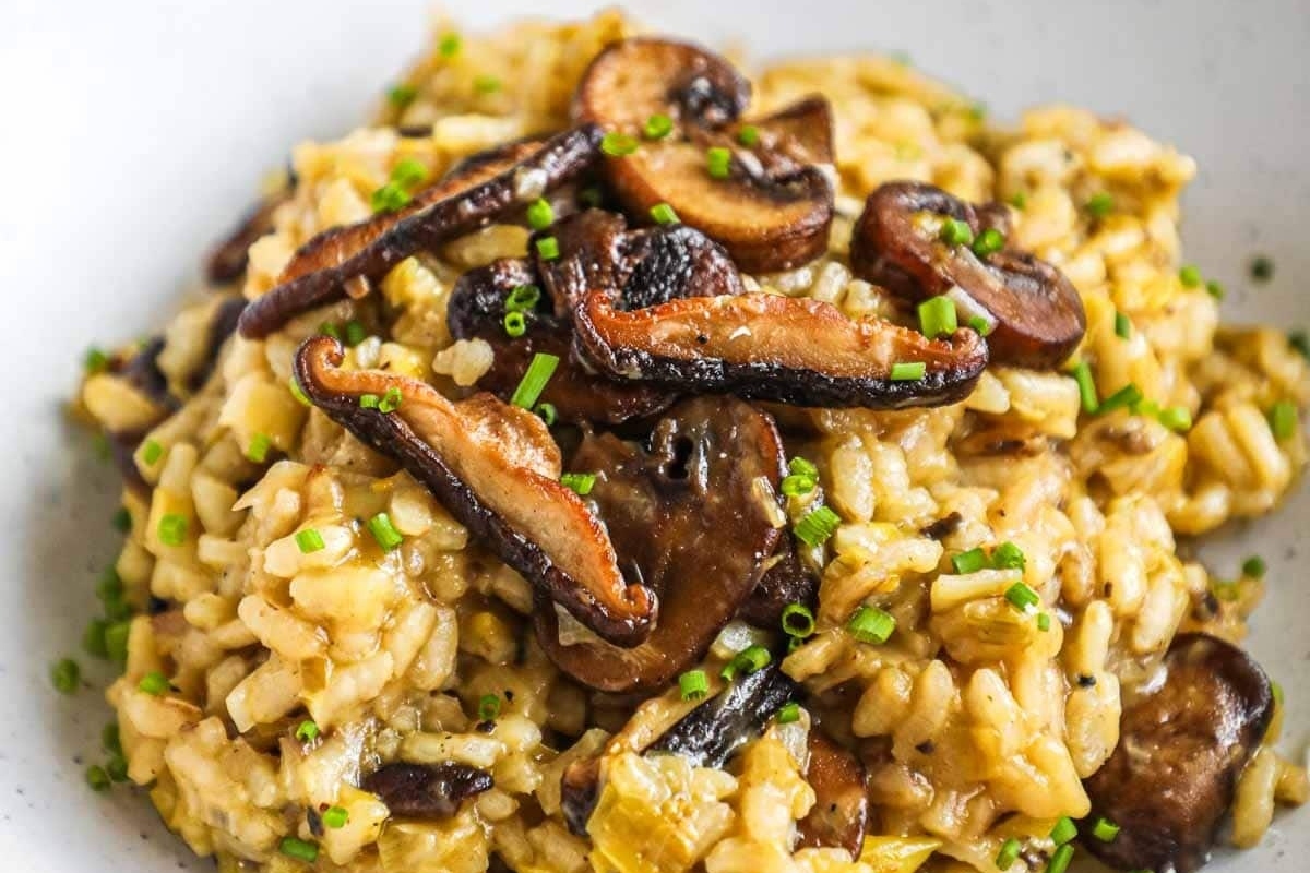 Elevate your mushroom risotto with a drizzle of indulgent truffle oil. Check out our delectable recipes for this creamy dish served in a white bowl.