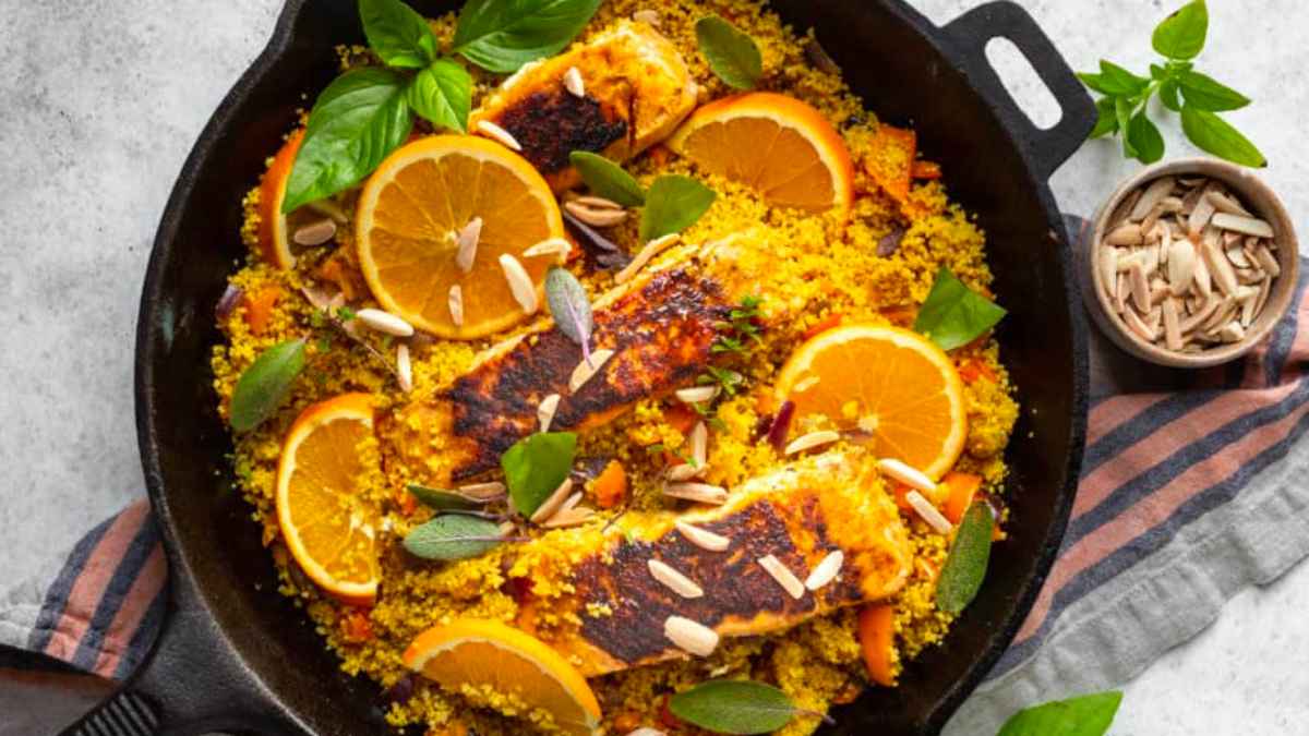 A romantic main dish of Couscous with salmon and oranges cooked in a skillet, perfect for celebrating Valentine's Day.