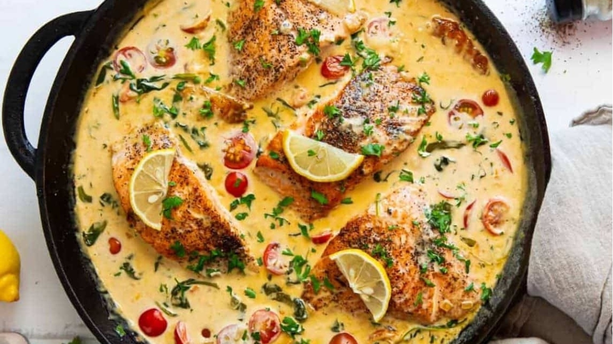 Salmon dinners in a skillet with lemon and garlic.