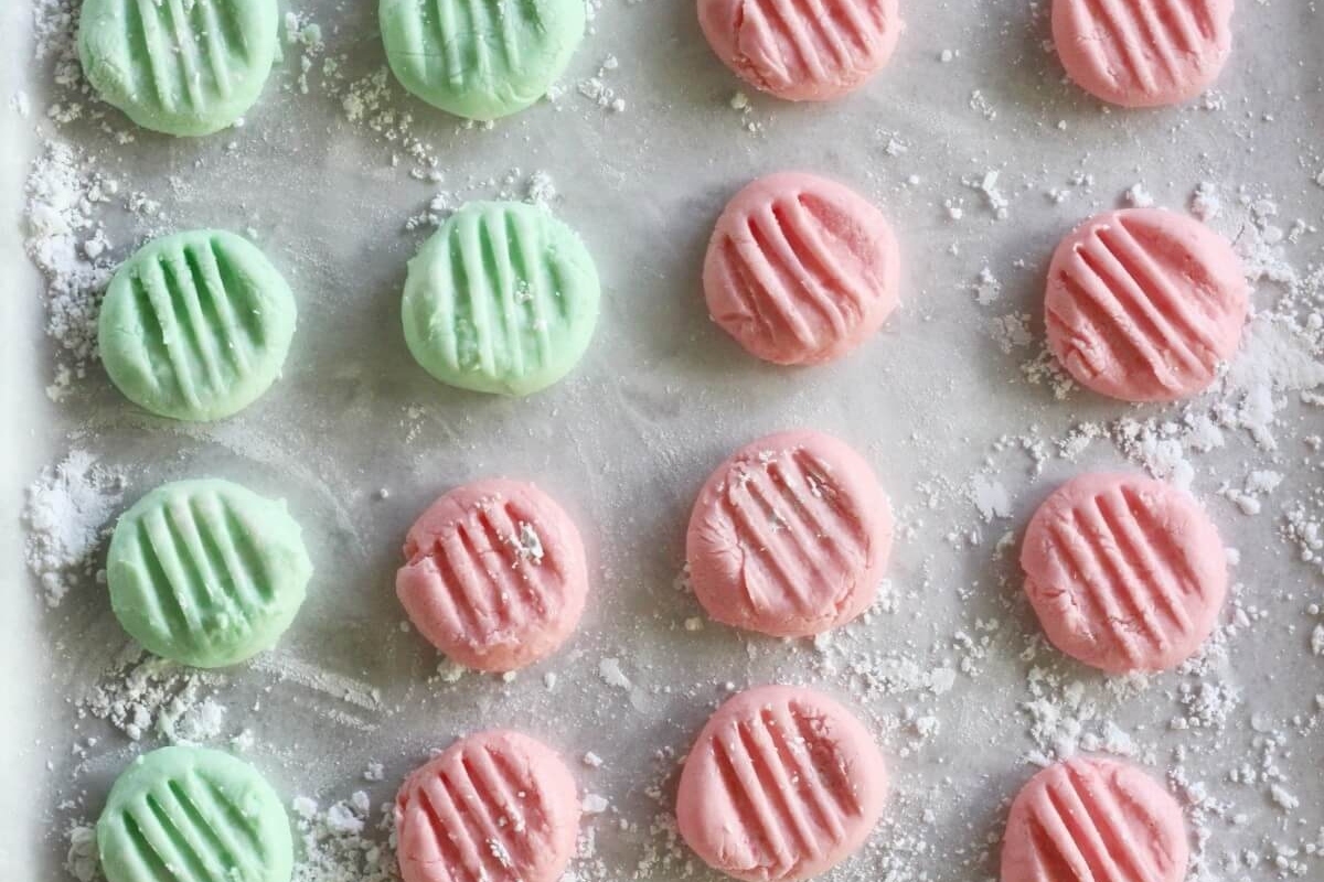Pink and green sugar cookies on a baking sheet. These festive treats are perfect for Christmas celebrations or any sweet occasion. The colorful combination of pink and green will add a touch of cheer to your dessert table