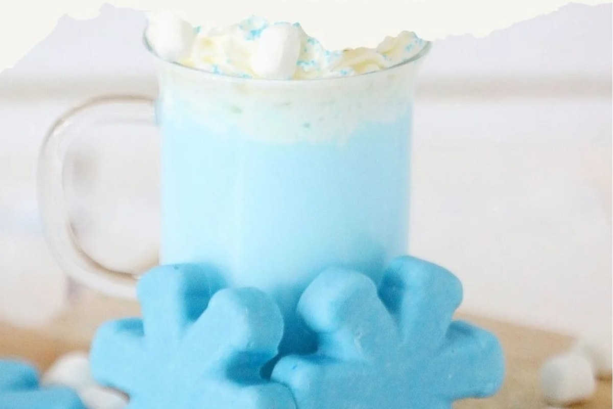         A cup of blue hot cocoa with marshmallows on top.