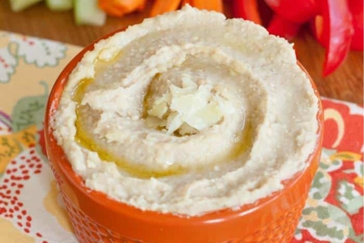 A delightful bowl of hummus with carrots and celery, perfect for quick and healthy snacks or appetizers.