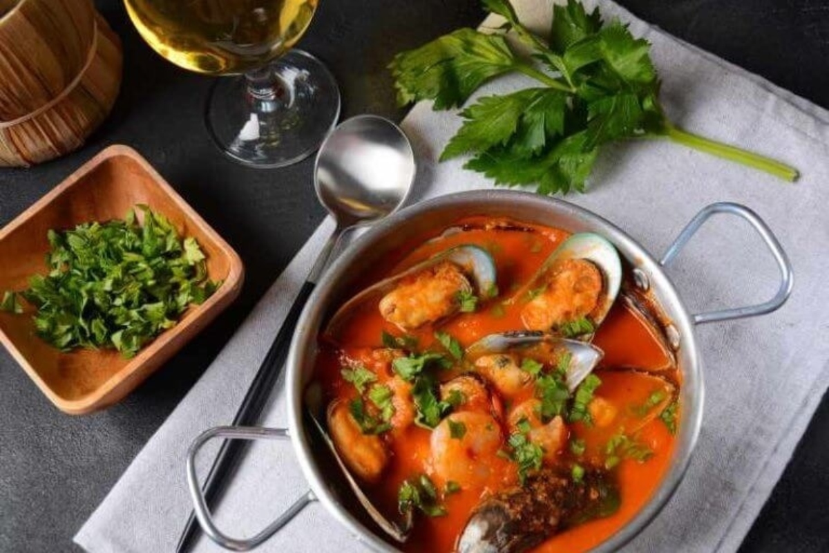 A feast of the seven fishes, showcasing a mouthwatering bowl of seafood stew paired elegantly with a glass of wine.