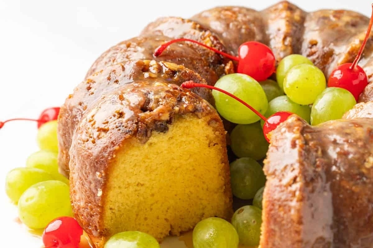 A bundt cake with grapes and raisins on a plate.