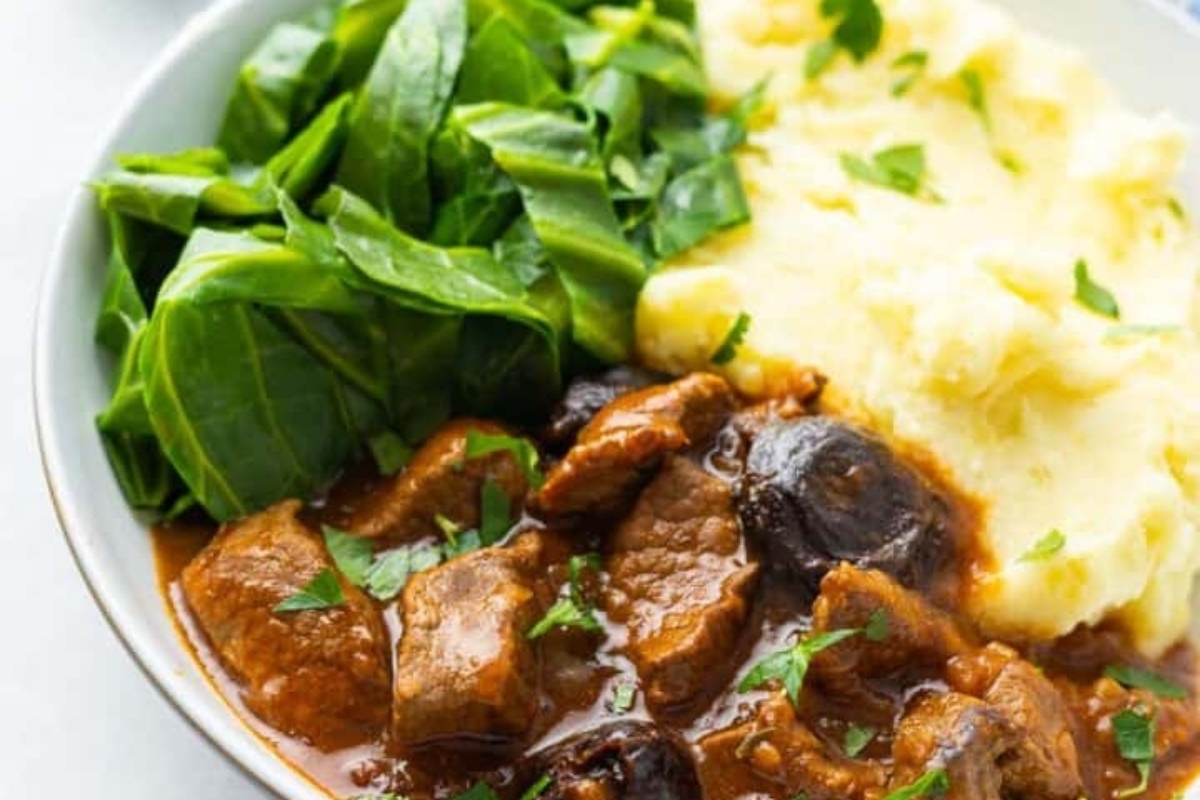 Beef stew recipe for winter, topped with mashed potatoes and spinach.