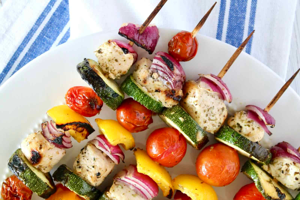 Game Day Grilled chicken skewers on a white plate.