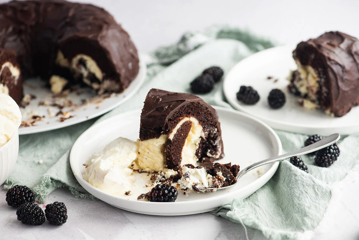 A delectable bundt cake adorned with whipped cream and juicy blackberries.