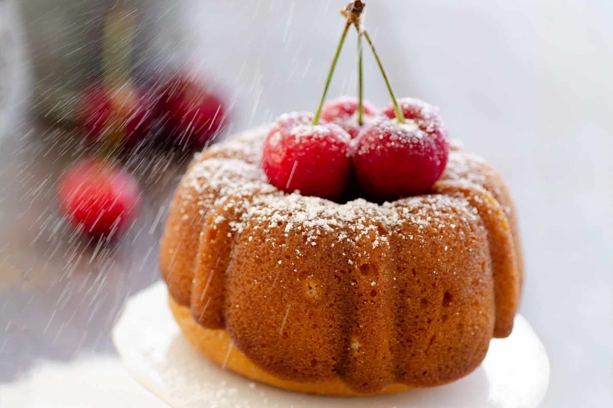 A Valentines' Day bundt cake with cherries and powdered sugar.