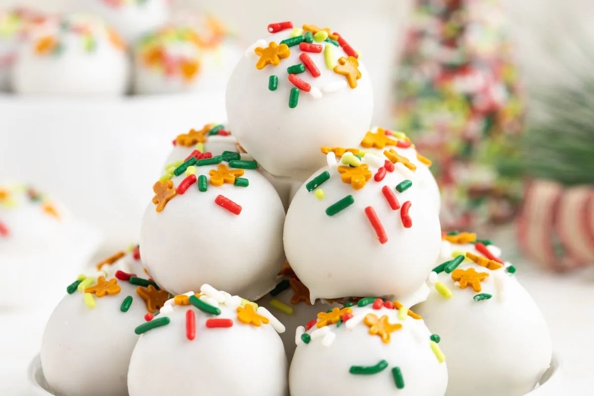 A stack of white egg balls with sprinkles on top, perfect for Christmas candy recipes.