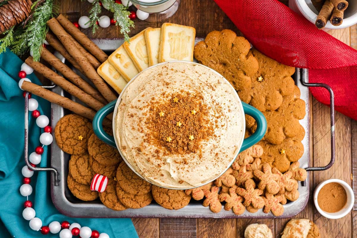 A festive tray of holiday cookies and a delicious dip displayed on a table.