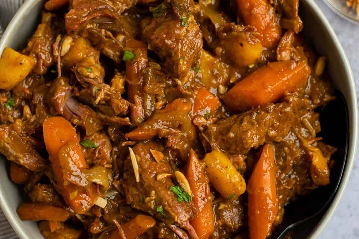 A slow cooker stew with beef, carrots, and potatoes.
