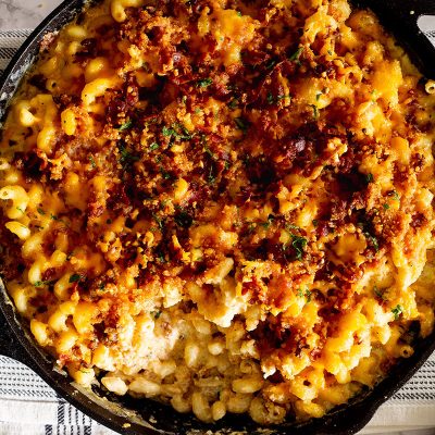 Loaded mac and cheese cooked in a cast iron skillet.