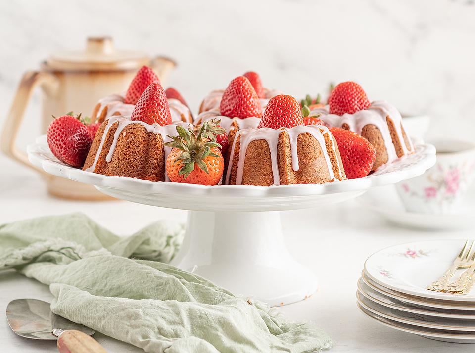 A bundt cake with strawberries on a white plate.