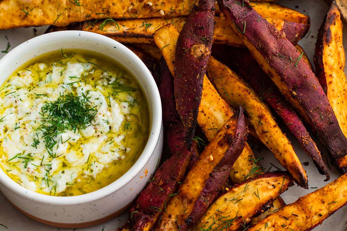 A plate of sweet potato fries with a dip, perfect for snacking or as a side dish. These fries are crispy on the outside and tender on the inside, offering a delicious contrast of