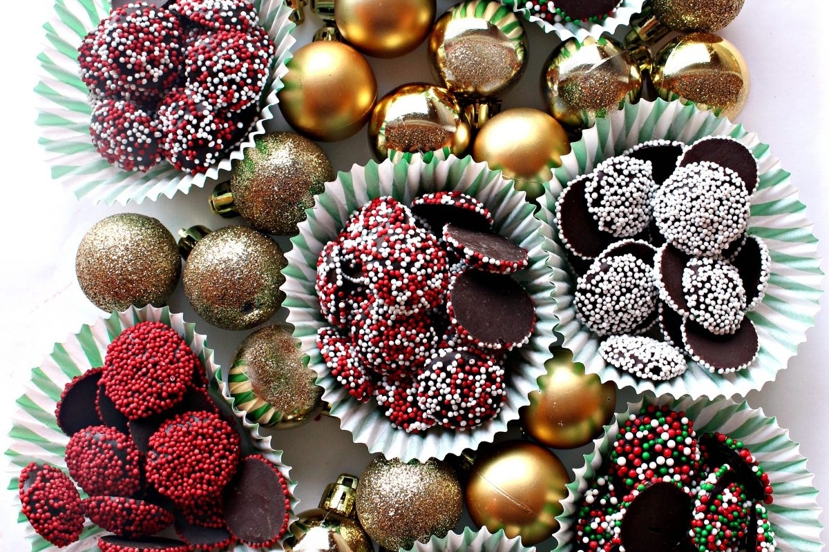 A variety of chocolate covered Christmas ornaments are arranged on a table, showcasing delectable candy creations.